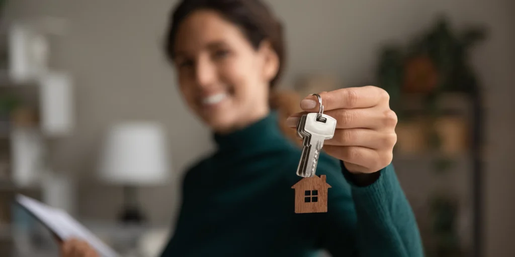 A woman holding out her house keys.